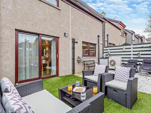 a patio with wicker chairs and a table at 3 Bed in Grantown on Spey 94514 in Grantown on Spey