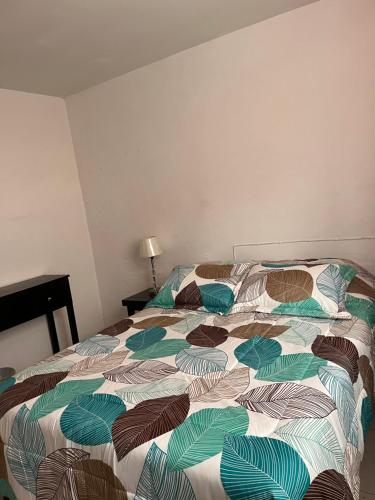 een bed met een kleurrijk dekbed in een slaapkamer bij Habitacion comoda en departamento planta baja in Guadalajara