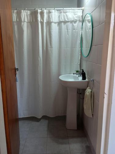 a bathroom with a shower curtain and a sink at Quinta El Cholito in Luján