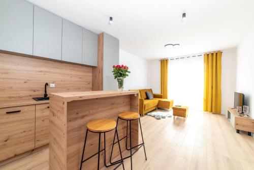 a kitchen and living room with a counter and stools at Premium Nakielska 46 przy Parku 40m2 garaż in Bydgoszcz