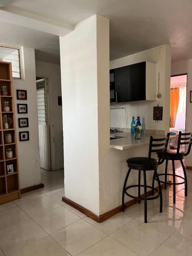 a kitchen with two chairs and a table in a room at Cuarto cómodo y económico cerca Expo GDL Plaza Sol in Guadalajara