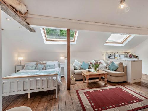 a bedroom with a bed and a couch and windows at 1 Bed in Eskdale 95105 in Eskdale