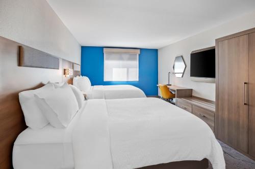a hotel room with a large white bed and a tv at Holiday Inn Express & Suites Tumwater - Olympia by IHG in Tumwater