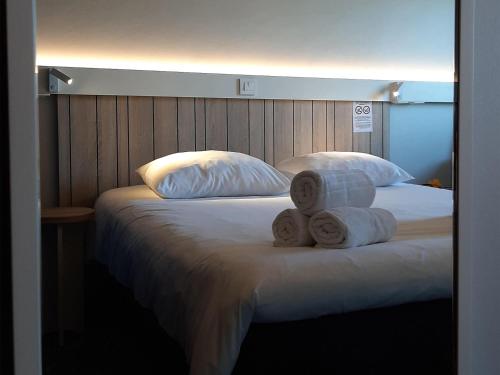 a bed with two rolls of towels on it at ibis Rennes Cesson in Cesson-Sévigné