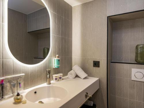 a bathroom with a sink and a mirror at Novotel Nice Arenas Aeroport in Nice