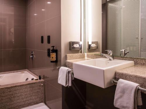 a bathroom with a sink and a bath tub at Novotel Sao Paulo Morumbi in Sao Paulo
