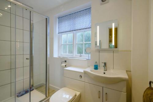 a bathroom with a sink and a shower and a toilet at Rose Cottage - West Runton in West Runton