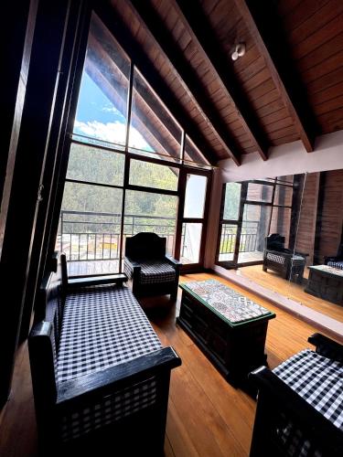 ein großer Raum mit Stühlen, einer Couch und Fenstern in der Unterkunft Casa familiar en centro de Quito in Quito