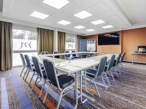 a conference room with a long table and chairs at Mercure Aachen Europaplatz in Aachen