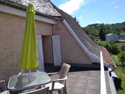 a green umbrella and two chairs on a patio at Gite a Firmi in Firmi