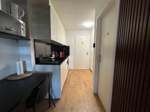 a kitchen with a black counter top and a hallway at Cosy private room in Lausanne center in Lausanne