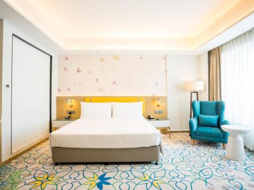 a bedroom with a bed and a blue chair at Hotel NYASHA Ox Suites Near Delhi Airport in New Delhi