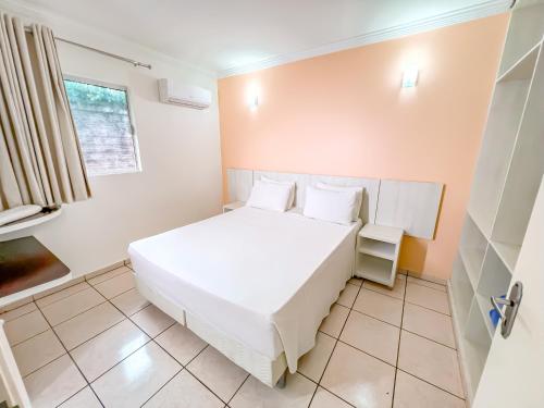 a small bedroom with a white bed and a window at diRoma Fiori direto com o Grupo diRoma com acesso ao Acqua Park e Café da manhã in Caldas Novas