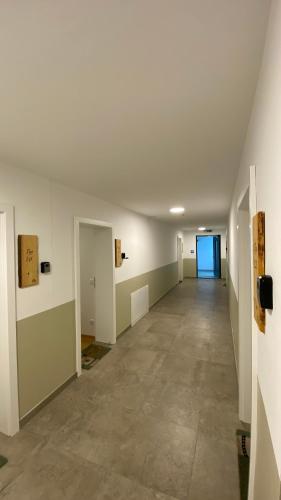 an empty hallway in an empty building with a door at Modernes Apartment am Traunsee - See, Berge, Fitness & Parkplatz in Altmünster