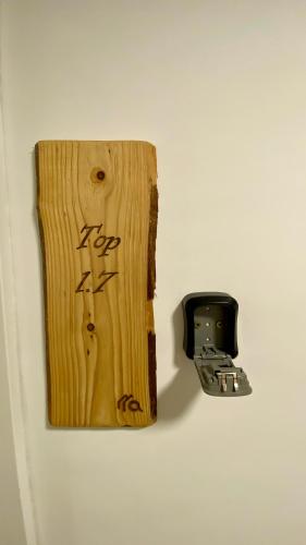 a piece of wood with writing on it next to a wall at Modernes Apartment am Traunsee - See, Berge, Fitness & Parkplatz in Altmünster
