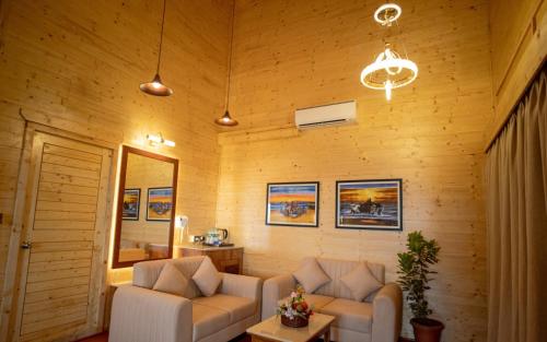 a living room with two couches and a mirror at La Cabana Beach & Spa, By Ashvem Beach in Mandrem