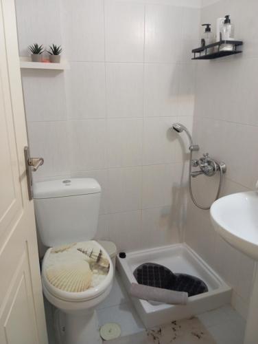 a bathroom with a toilet and a sink at Garden studio in Piraeus