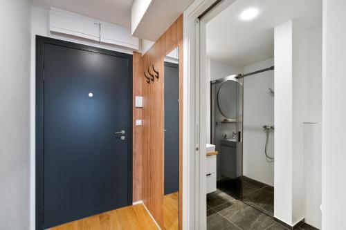 a hallway with a black door and a bathroom at Apartmány Klement in Znojmo