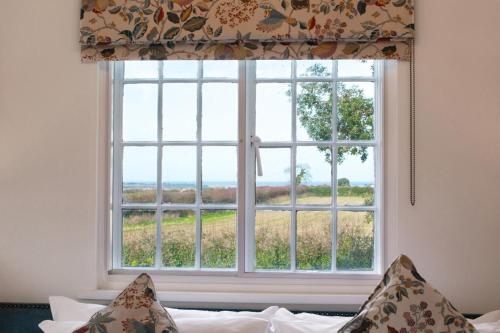 a window with a view of a field at Cuckoo Lodge in Wighton