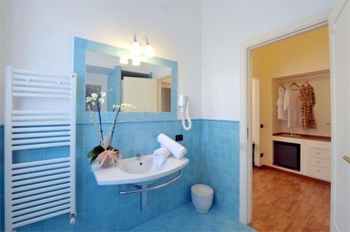 a blue tiled bathroom with a sink and a mirror at Residenza Villa Titina in SantʼAgata sui Due Golfi