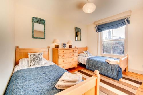 a bedroom with two beds and a window at Point Cottage in Blakeney