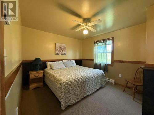 a bedroom with a bed and a ceiling fan at Mayfield Country Cottages in Cavendish