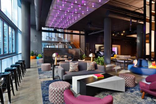 a lobby with a couch and chairs and tables at Aloft Chicago Mag Mile in Chicago