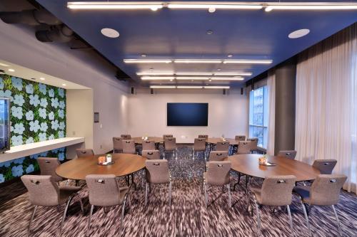 a conference room with tables and chairs and a screen at Aloft Chicago Mag Mile in Chicago