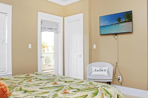 a bedroom with a bed and a white chair at Barefoot Cottage B49 - Seabbatical by Pristine Properties Vacation Rentals in Highland View