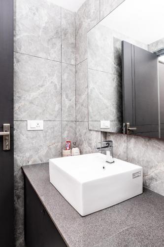a bathroom with a white sink and a mirror at NivoNest in Gurgaon
