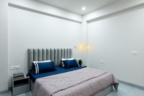 una camera da letto con letto con lenzuola blu e cuscini blu di NivoNest a Gurgaon