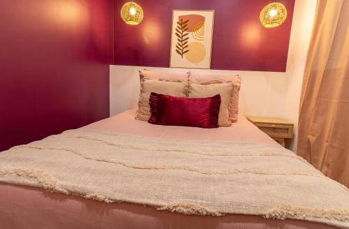 - un lit avec un oreiller rouge dans l'établissement Siloé - Balnéo - Stationnement gratuit dans la rue- Gare 10 min à pied, à Troyes