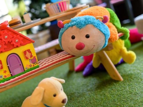 a toy monkey sitting on a bench next to a toy dog at Novotel Nürnberg am Messezentrum in Nürnberg