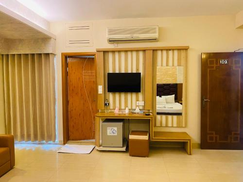 a living room with a desk and a television at Hotel Beach Way in Cox's Bazar