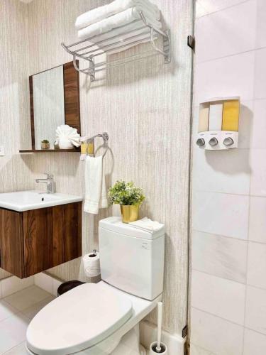 a bathroom with a white toilet and a sink at Upscale Centric Apt, City Views in Santo Domingo