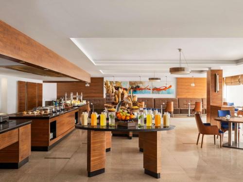 a restaurant with tables with fruits and drinks on them at Novotel Cairo Airport in Cairo