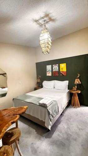 a bedroom with a large bed and a chandelier at Kitnet Sertão na Ilha do Ferro AL in Pão de Açúcar