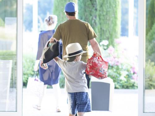 a young boy holding a hat and shopping bags at Novotel Nottingham Derby in Long Eaton