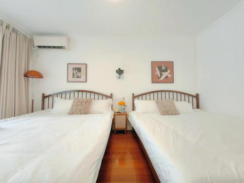 two beds sitting next to each other in a bedroom at Tonight Homestay Jing'an Temple Branch Shanghai in Shanghai