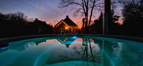 a house with a swimming pool in front of a house at Goldenescape 6P Vip huis met Royale tuin en hottub 110 in Ewijk