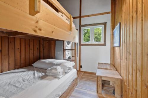 a bedroom with a bunk bed and a wooden wall at Stunning Mountain Getaway with Open Concept Design in Blue Mountains