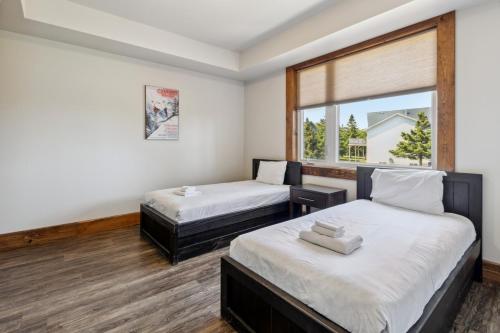 deux lits dans une chambre avec une fenêtre dans l'établissement 8 BR Luxury Swiss Style Chalet w Hot Tub, à Blue Mountains