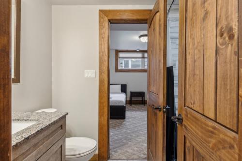 une salle de bain avec des toilettes, un lavabo et une porte dans l'établissement 8 BR Luxury Swiss Style Chalet w Hot Tub, à Blue Mountains