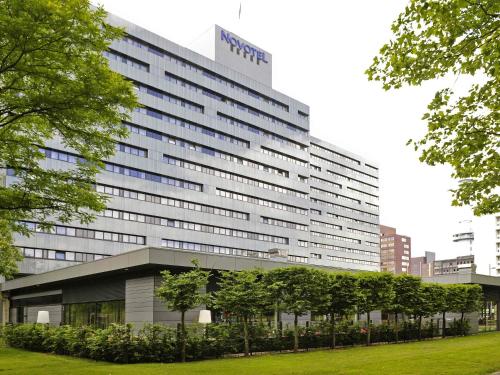 a large building with trees in front of it at Novotel Amsterdam City in Amsterdam