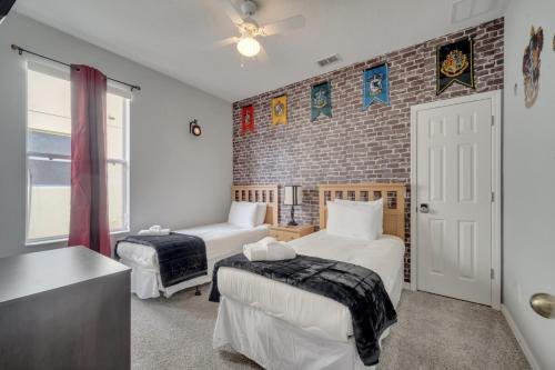 基西米Disney Getaway Pool Gated Resort Near Parks的一间卧室，有两张床和一堵砖墙
