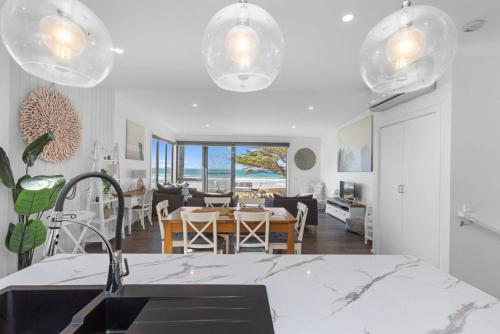 Una cocina y una sala de estar con mesa y sillas. en Blue Sea - Beachfront Escape, en Apollo Bay