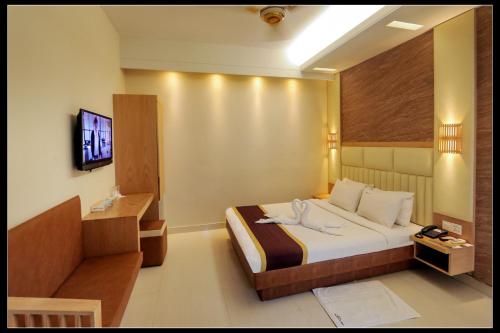 a hotel room with a bed and a flat screen tv at Hotel Beach Way in Cox's Bazar