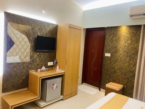 a hotel room with a bed and a tv on the wall at Hotel Beach Way in Cox's Bazar