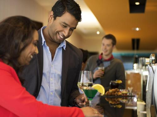 a man and a woman holding a glass of wine at Novotel Rotterdam - Schiedam in Schiedam