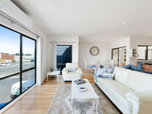 a living room with a white couch and a table at PROVINCIAL ON PASCOE - everything at your doorstep in Apollo Bay